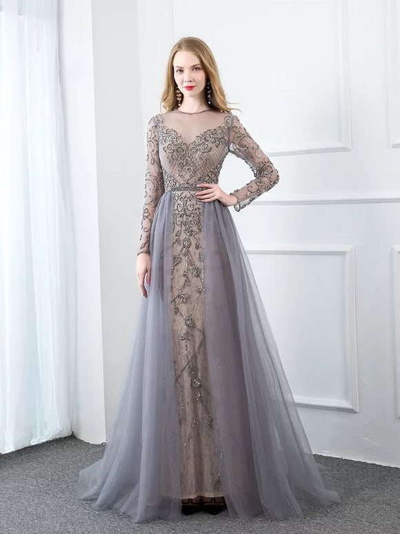 The grey floor length ASIYA evening dress comes with a beautiful detailed top filled with beads. The dress is completed with a stunning grey tulle skirt. It is available in both long and short sleeve.